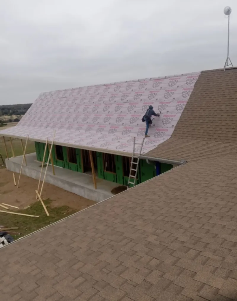 Worker preparing underlayment for a metal roof installation in Lewiston